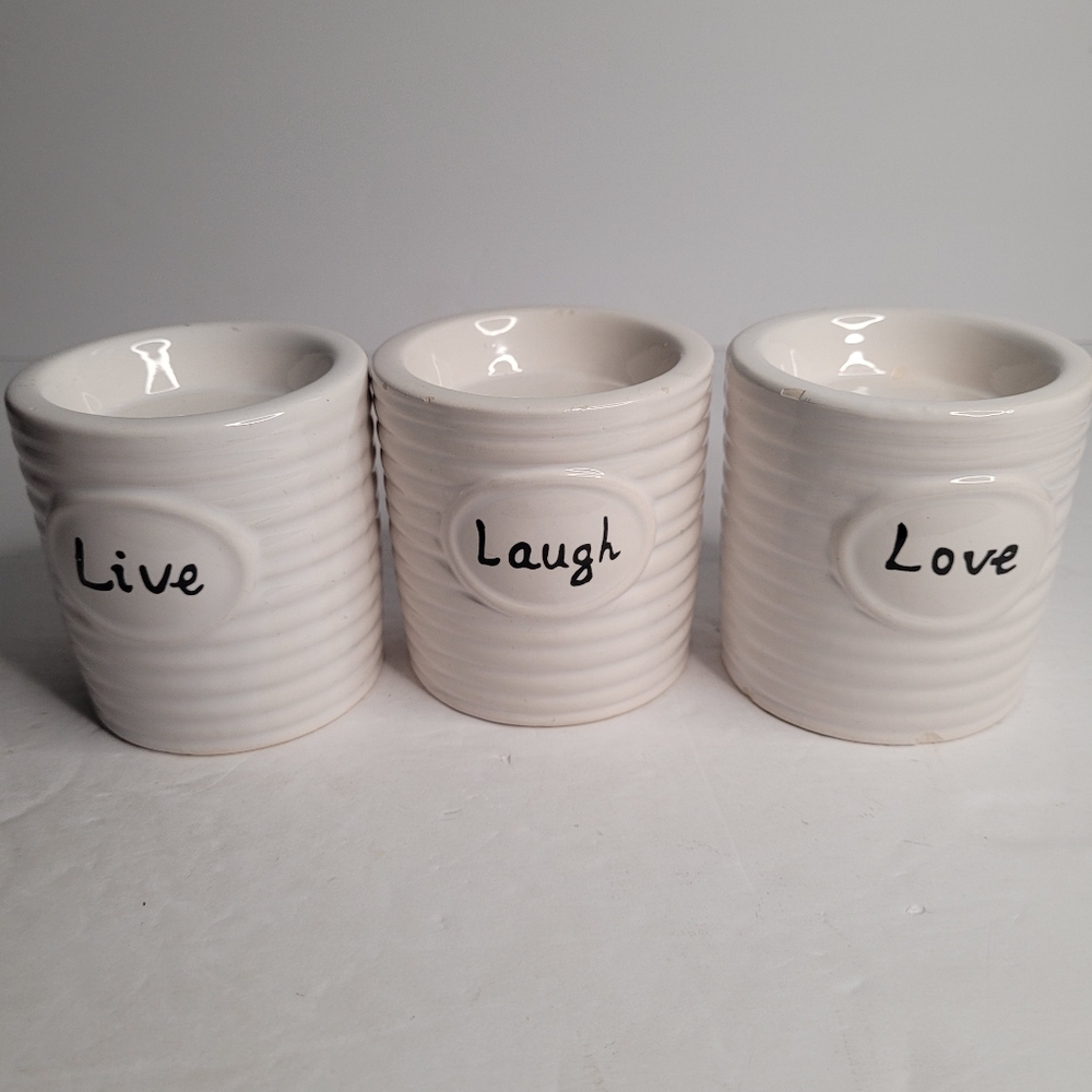Three white ceramic candle holders. 281